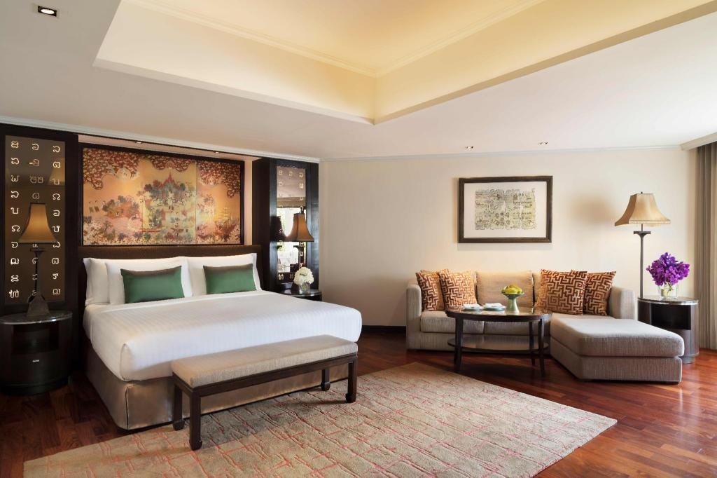 Guest bedroom with sitting area at Anantara Riverside Bangkok Resort
