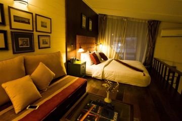 Guest bedroom with wooden floor and seating at Arun Residence