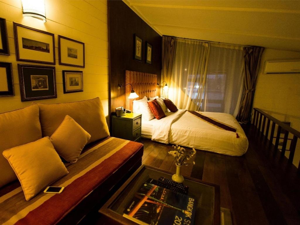 Guest bedroom with wooden floor and seating at Arun Residence
