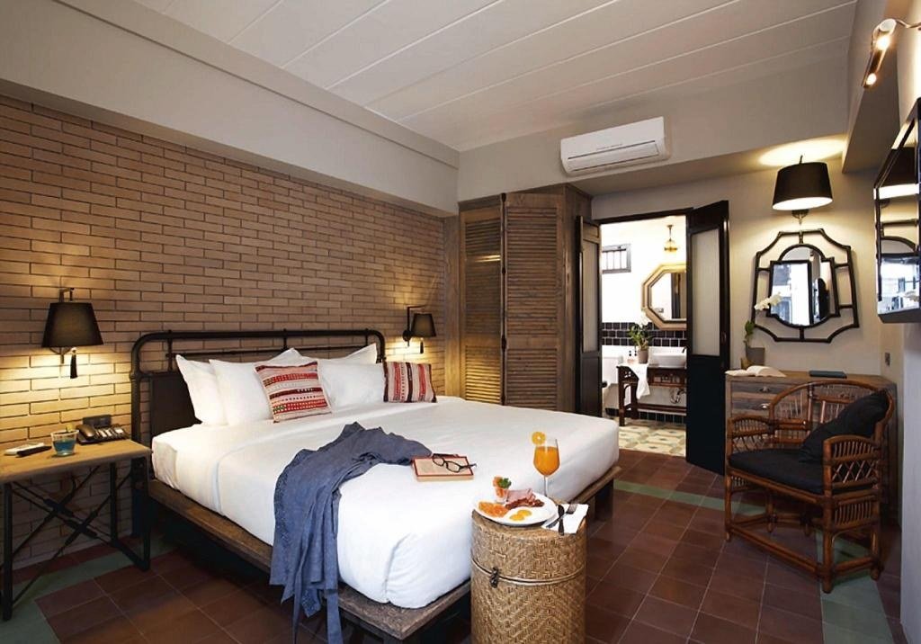 Guest bedroom with wood-panelled wall at Baan Chart Hotel