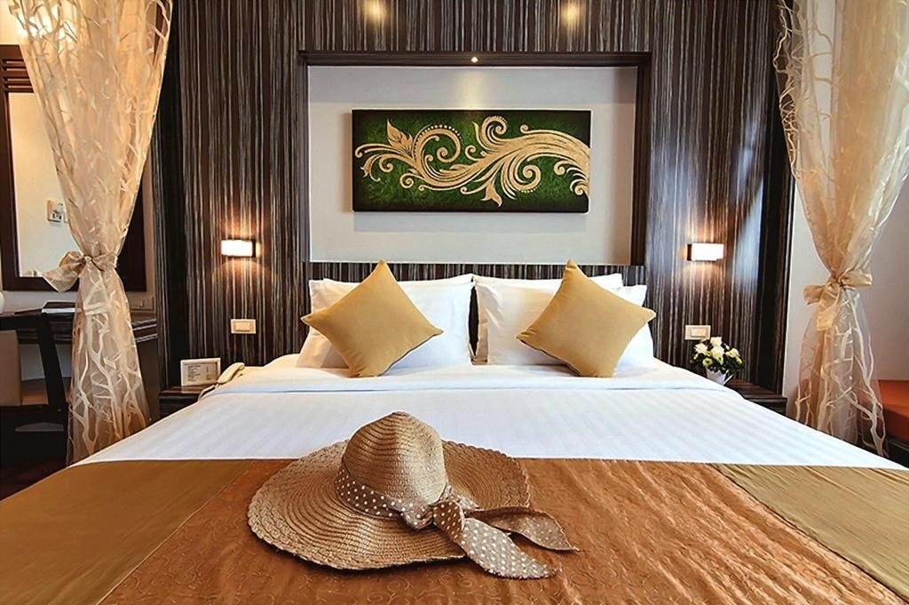 Guest bedroom with towel decoration at Bossotel Hotel