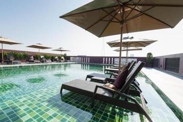 Rooftop pool with umbrellas at Casa Nithra Bangkok