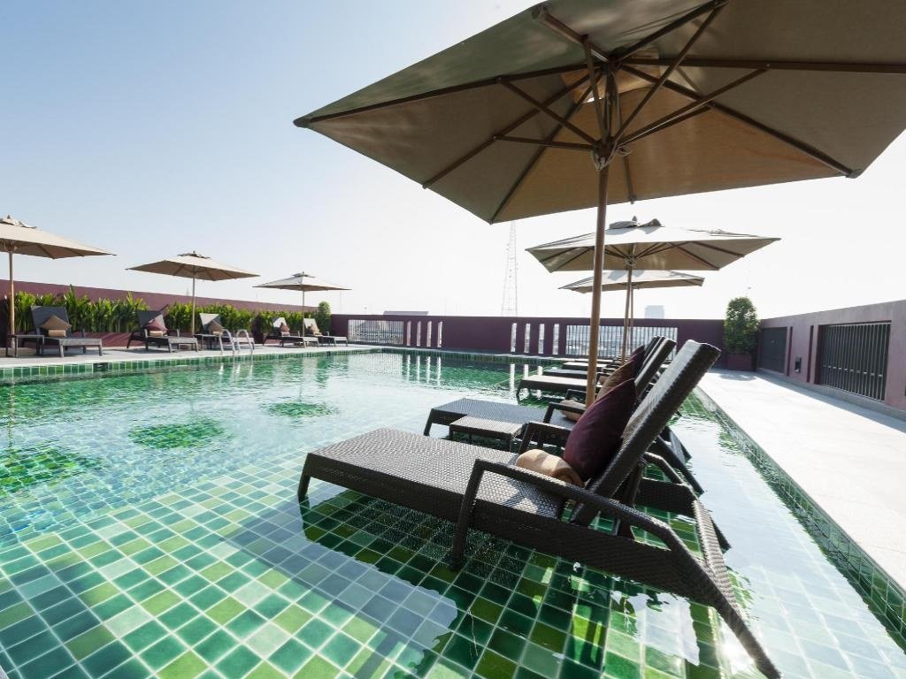 Rooftop pool with umbrellas at Casa Nithra Bangkok