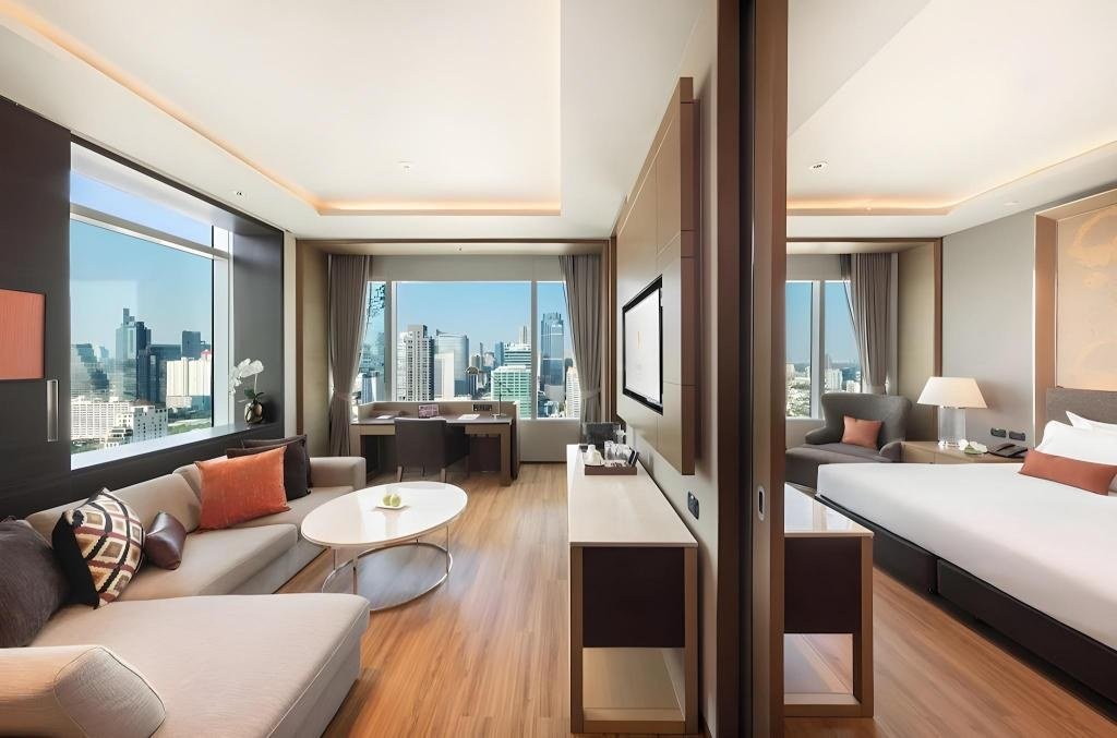 Guest bedroom with large windows at Eastin Grand Hotel Sathorn