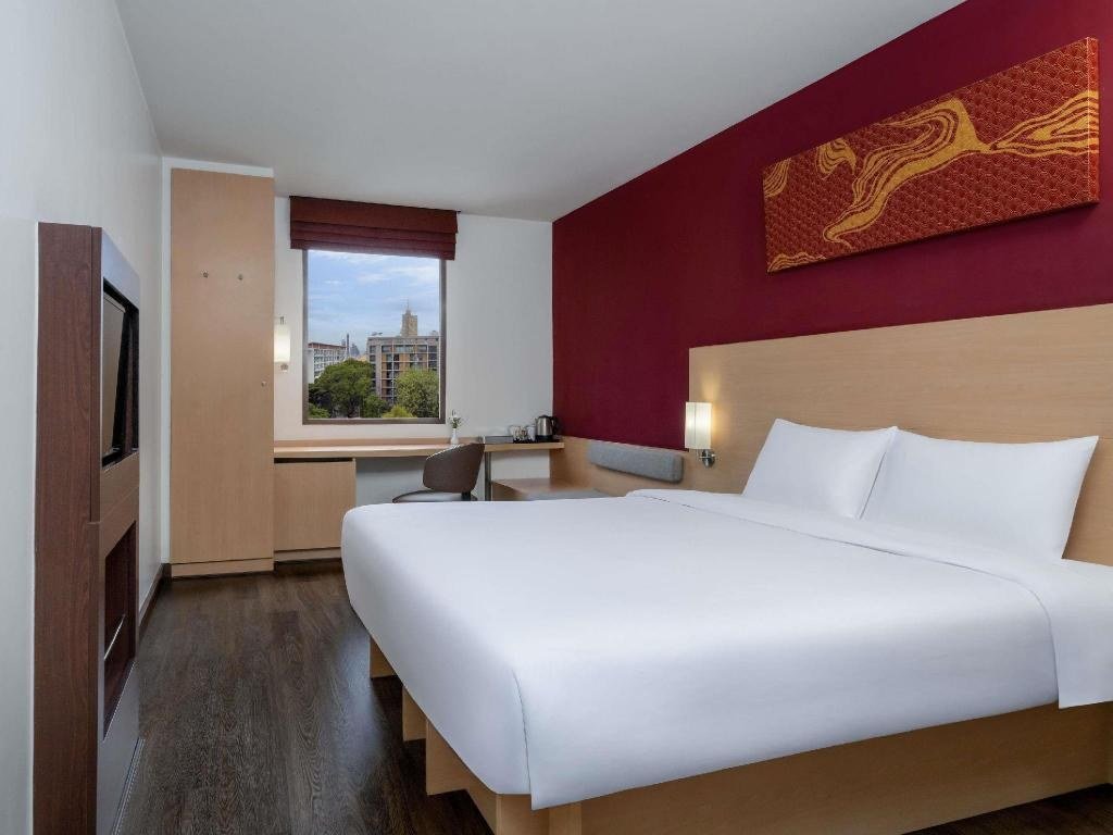 Guest bedroom with coloured feature wall at ibis Bangkok Riverside