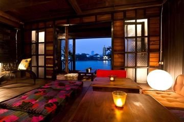 Wood-panelled dining space beside the river at Loy La Long Hotel