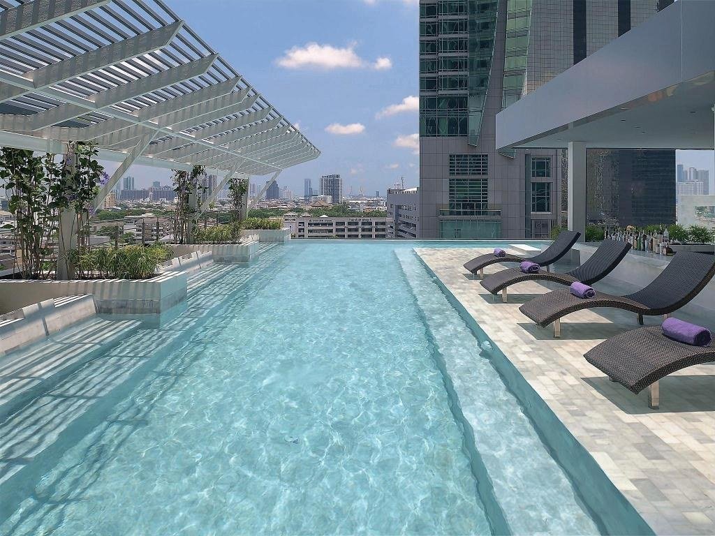 Outdoor swimming pool and sun loungers at Mode Sathorn Hotel