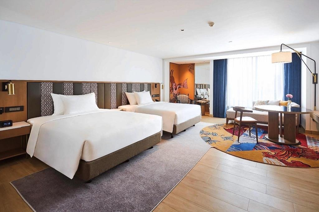 Twin guest bedroom with sitting area at Montien Hotel Surawong Bangkok