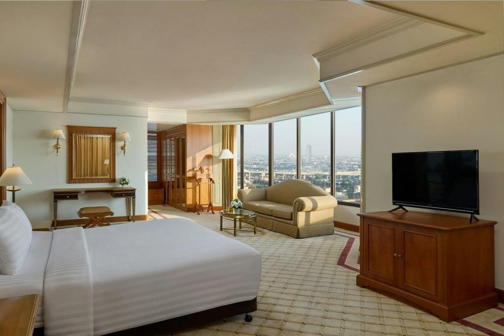 Guest bedroom with sitting area at Montien Riverside Hotel Bangkok