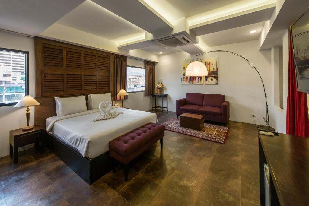 Guest bedroom with wooden bed frame at Nanda Heritage Hotel