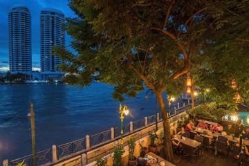 Riverside dining terrace at night at New Siam Riverside
