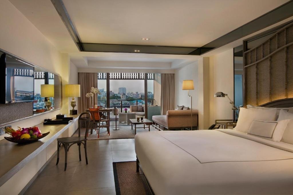 Guest bedroom with sofa seating at Riva Surya Bangkok Hotel