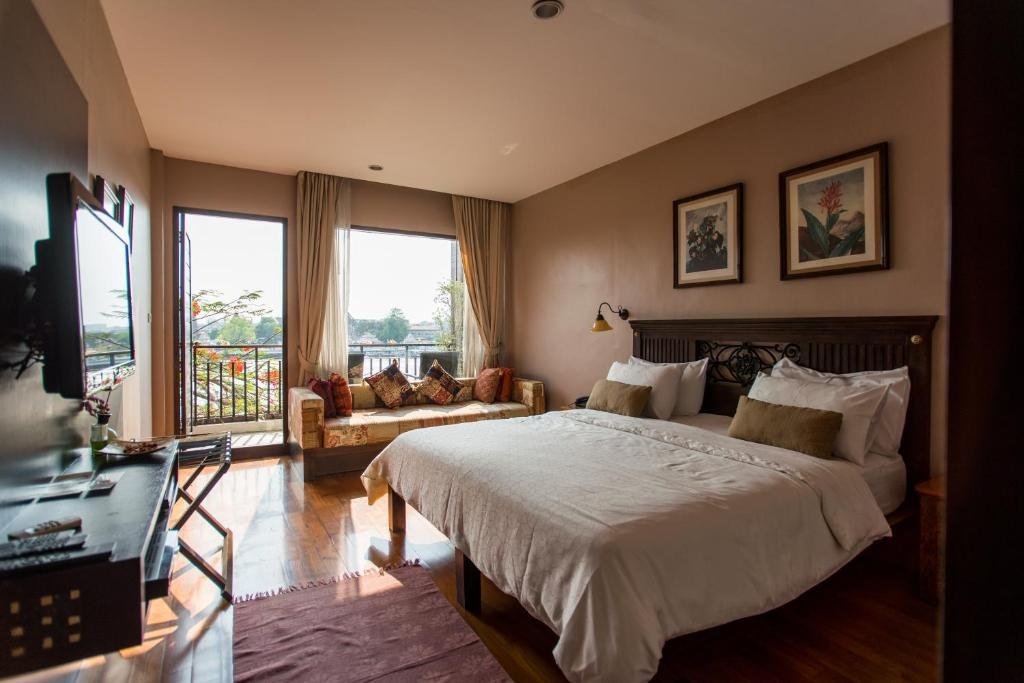 Guest bedroom with wood flooring at Sala Arun