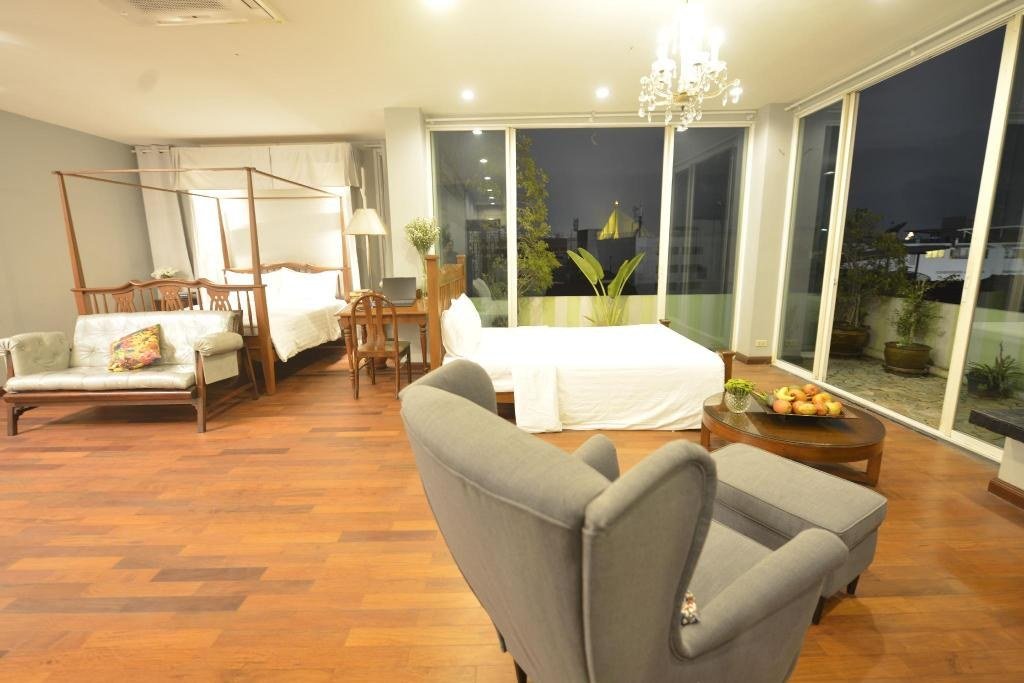 Twin guest bedroom with seating at Sourire at Rattanakosin Island Hotel