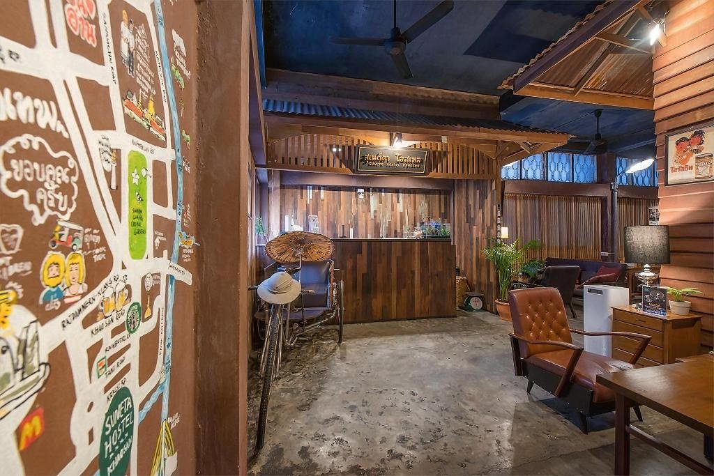 Wood-panelled reception and common area at Suneta Hostel Khaosan