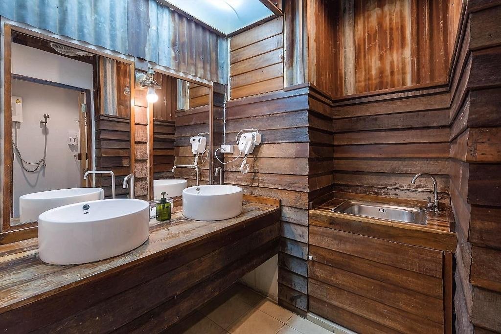 Double washbasins in a wood-panelled bathroom at Suneta Hostel Khaosan