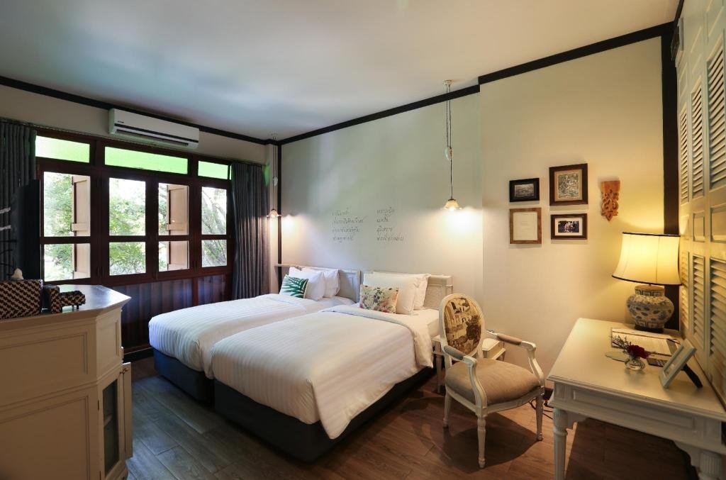 Guest bedroom with tall windows at The Raweekanlaya Bangkok Wellness Cuisine Resort
