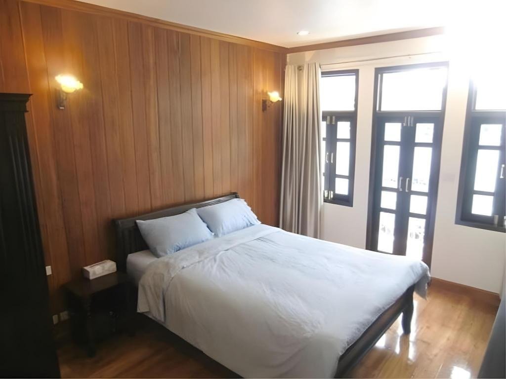 Wood-panelled guest bedroom at The Royal ThaTien Village